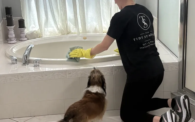 Tidy Standard team member detail-cleaning a soaking tub